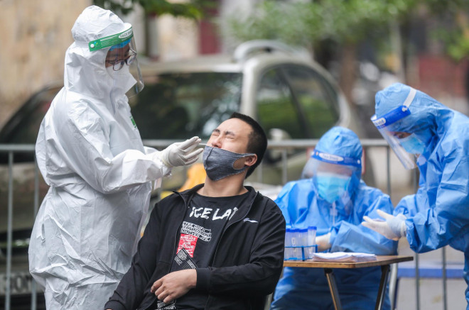 Nhân viên y tế đang thực hiện lấy mẫu xét nghiệm Covid-19 cho người có liên quan đến 20 ca F0 thuộc phường Nguyễn Du