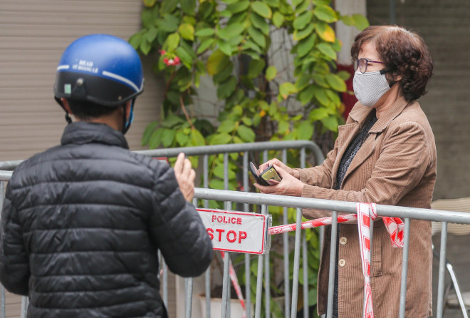 Người dân đang tiếp tế nhu yếu phẩm hoặc đồ dùng cá nhân vào khu vực bên trong