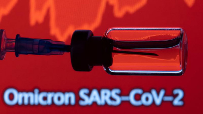 Một lọ và ống tiêm được nhìn thấy phía trước biểu đồ hiển thị dòng chữ Omicron SARS-CoV-2, ngày 27-11. Ảnh: REUTERS