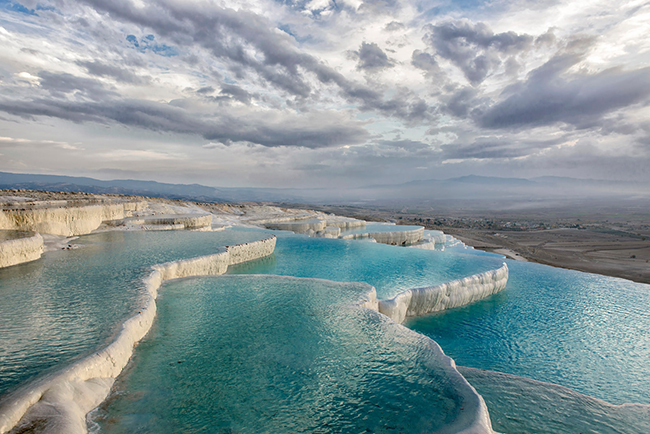 Pamukkale, Denizli, Thổ Nhĩ Kỳ: Các hồ bơi 17 tầng của Pamukkale (“lâu đài bông” trong tiếng Thổ Nhĩ Kỳ) đẹp tuyệt vời. Làn nước màu trắng sữa ấm áp phản chiếu hoàn hảo bầu trời trong xanh của nơi này. 
