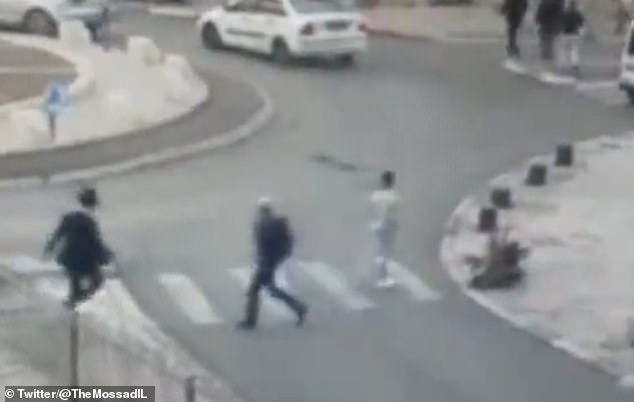 Thanh niên Palestine đi bộ sang đường, mang theo dao trong người.