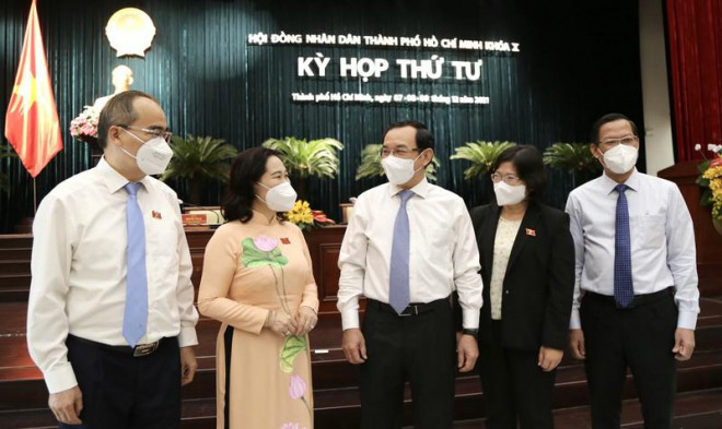 Bí thư Thành uỷ TP.HCM Nguyễn Văn Nên trao đổi với lãnh đạo TP bên lề kỳ họp HĐND TP, sáng 7-12. Ảnh: HOÀNG GIANG