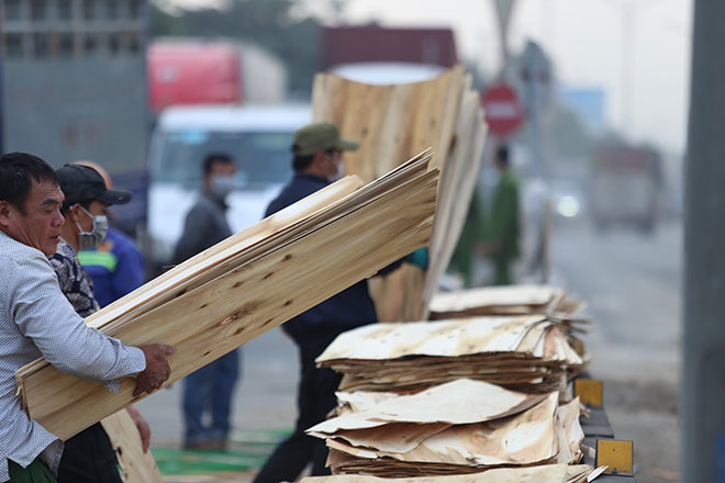 &nbsp; Lực lượng chức năng cùng người dân hỗ trợ tài xế thu gom gỗ ép tràn ra đường