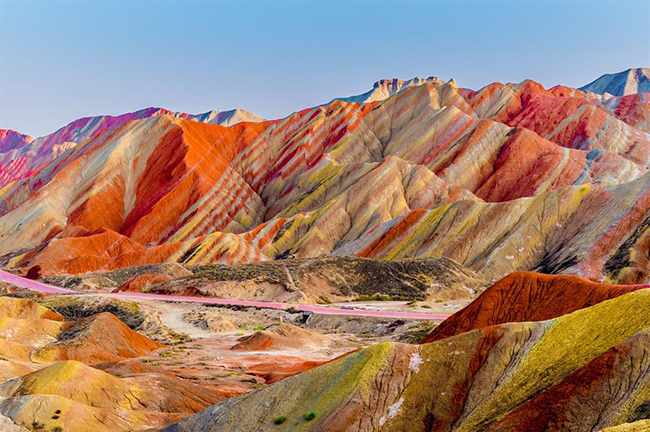 Những ngọn núi bảy sắc cầu vồng ở Công viên Địa chất Quốc gia Zhangye trông giống như bảng màu sơn của một nghệ sĩ. Là Di sản Thế giới được UNESCO công nhận, sự hình thành tuyệt đẹp này được tạo ra bởi sự xói mòn tự nhiên, khi các lớp cát, phù sa, sắt và khoáng chất hòa trộn với nhau để tạo ra một kính vạn hoa đầy màu sắc. 

