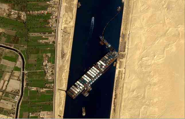 8. Bức ảnh từ trên cao chụp con tàu
hàng Ever Given gặp sự cố nằm chắn ngang kênh đào Suez ở Ai Cập
ngày 27/3. Tàu gặp sự cố sau khi bị gió giật và chặn đứng tuyến vận
tải biển quan trọng trong suốt 6 ngày, khi thế giới đang gặp nhiều
vấn đề về chuỗi cung ứng. (Ảnh: Getty Images)