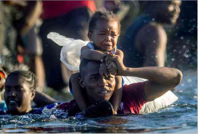 22. Người tị nạn Haiti ở Del Rio,
bang Texas, Mỹ, vượt sông Rio Grande để quay lại Mexico ngày 20/9.
Khi giới chức Mỹ bắt đầu trục xuất người tị nạn trở lại, hàng ngàn
người phải chờ trong lều tạm dưới gầm cây cầu quốc tế ở Del Rio
trong khi nhiều người khác vượt sông để tránh bị trục xuất. (Ảnh:
Getty Images)