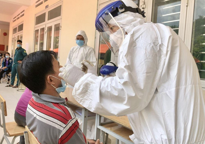 Nhân viên y tế lấy mẫu xét nghiệm tại trường Tiểu học Nghĩa Thọ. Ảnh: T.Trưc