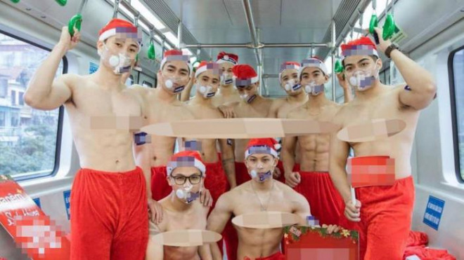 Nhóm nam thanh niên cởi trần cầm biển quảng cáo chụp ảnh trên tàu điện Cát Linh - Hà Đông