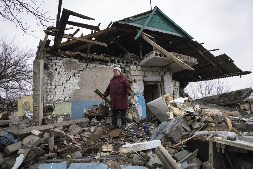 Bà Liudmyla Momot nhặt nhạnh những vật dụng còn sót lại sau khi căn nhà của mình đổ sập do pháo kích (ảnh: AP)