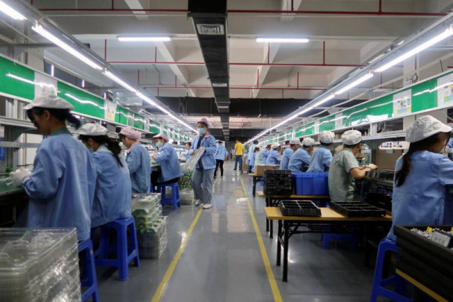 Công nhân làm việc tại một nhà máy ở TP Đông Hoản, tỉnh Quảng Đông – Trung Quốc hôm 7-12. Ảnh: REUTERS