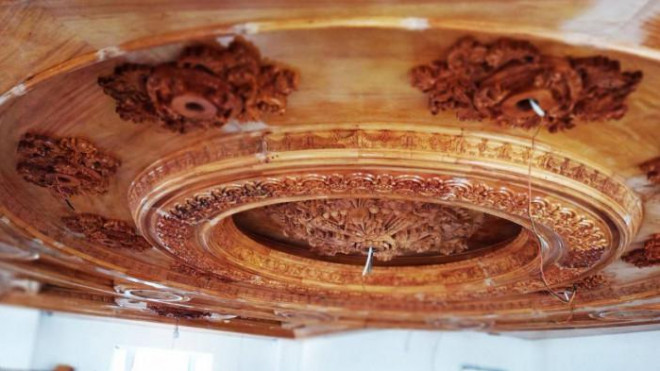 Ở tầng 1, từ cầu thang nhìn lên, gia
chủ đã cho làm trần ốp gỗ, với những họa tiết chạm trỗ vô cùng độc
đáo và tinh xảo, tăng thêm sự lộng lẫy của căn nhà. Ông nói, sau
khi lắp gỗ xong sẽ cho dát vàng Ý.