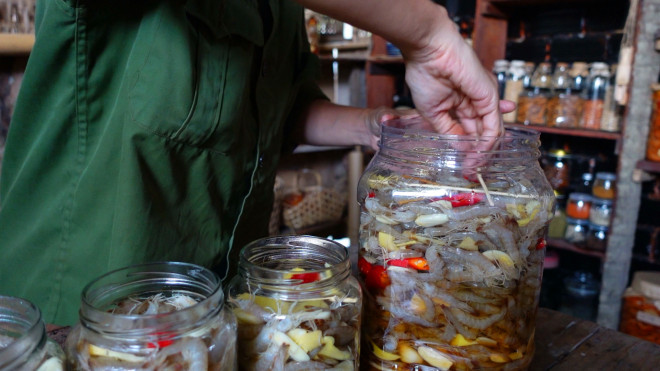 Dùng tre sạch gạt phía trên, cho giấm, nước mắm vào ngập cả hũ