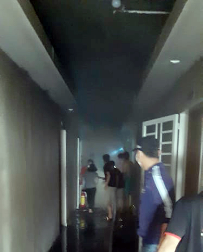 Người dân và cảnh sát tiếp cận căn hộ cháy để cứu người