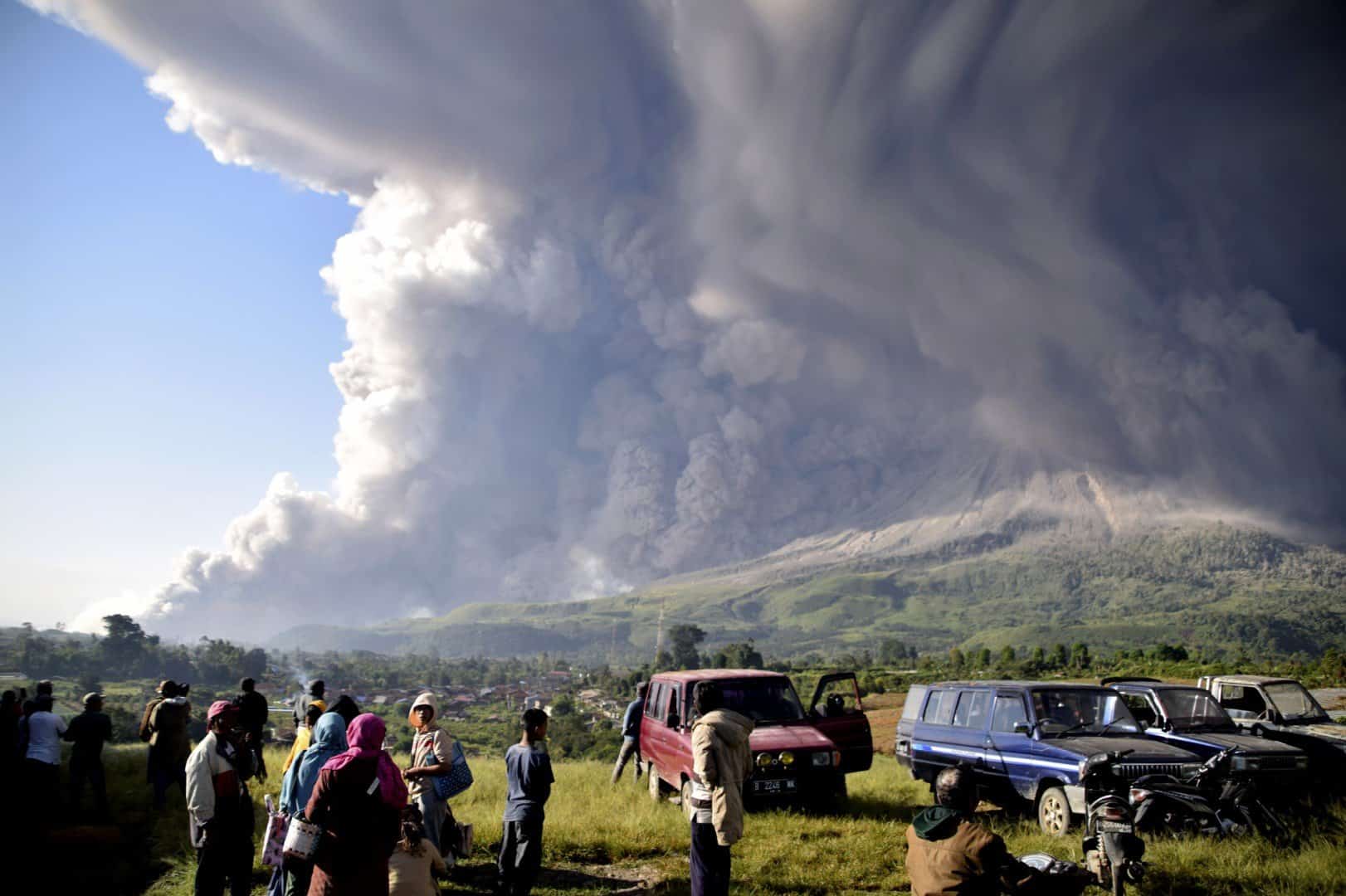 Người dân ở huyện Karo, tỉnh Bắc Sumatra, Indonesia đứng nhìn núi lửa Sinabung "thức giấc" hôm 2/3. Indonesia nằm giữa "Vành đai lửa Thái Bình Dương", một khu vực hoạt động địa chấn mạnh, nơi các mảng kiến tạo va vào nhau tạo ra một số lượng lớn các trận động đất và núi lửa. Quốc gia Đông Nam Á này có gần 130 núi lửa đang hoạt động, nhiều hơn mọi quốc gia trên thế giới. Ảnh: AP