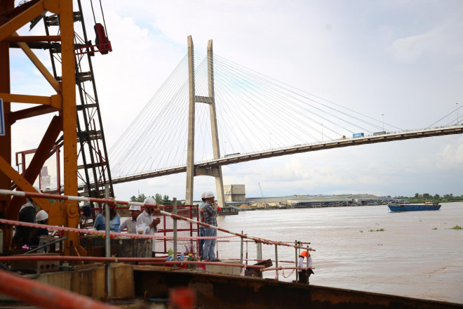 Lúc này, có 3 công nhân đứng ở khu vực sàn công tác kiểm tra các mối nối kết cấu sau thời gian mưa bão (do ảnh hưởng bão Noru).