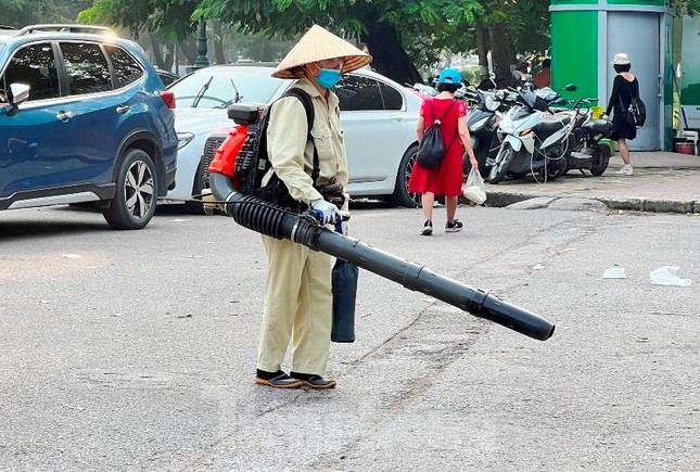 Từ việc dùng chổi và đẩy xe đi theo để thu gom rác, hiện trên nhiều tuyến phố Hà Nội lại xuất hiện những công nhân vệ sinh "cõng" máy nén khí và ống thổi rất cồng kềnh.
