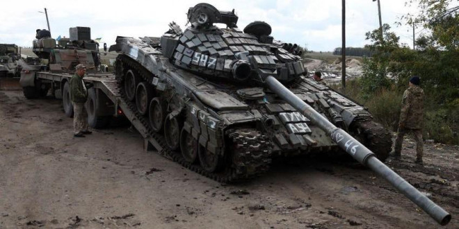 Lực lượng Ukraine đưa một xe tăng T-72 của Nga lên một xe tải bên ngoài thị trấn Izyum ngày 24-9. Ảnh: ANATOLII STEPANOV/Getty Images