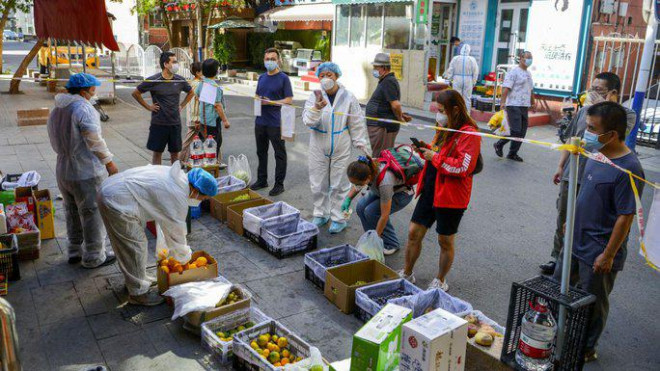 Người dân bị ngăn cách khu mua thực phẩm ở Tân Cương. Ảnh: Reuters