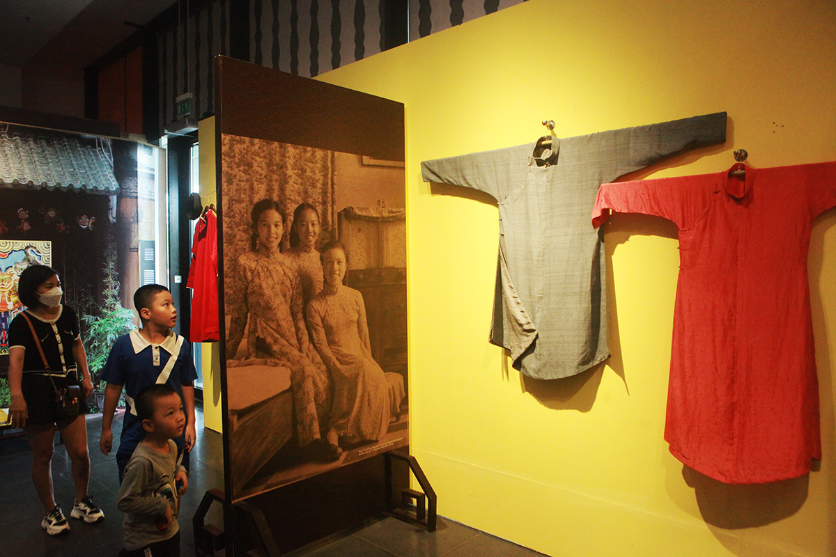 Ảnh tư liệu thiếu nữ Hà Nội với trang phục áo dài và hình ảnh áo ngũ thân 5 khuy, tay chẽn thời kỳ này rất được ưa dùng cho cả đàn ông (trái) và phụ nữ (phải). Khi mặc chỉ cài 4 chiếc, để hở khuy cổ