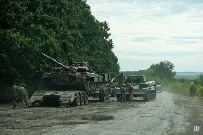 Lính Ukraine chuẩn bị vận chuyển chiếc xe tăng thu giữ được của Nga vào ngày 11-9 ở tỉnh Kharkiv. Ảnh: REUTERS
