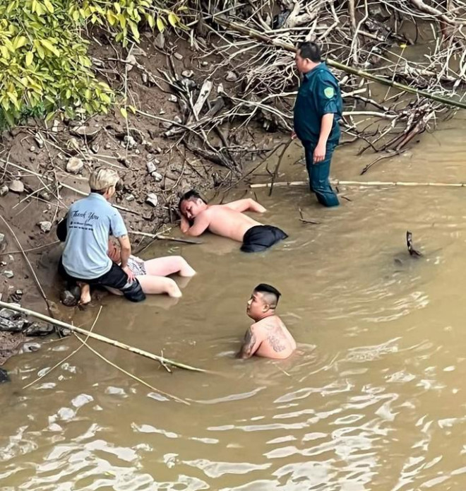 Người đàn ông ra cứu người kiệt sức, nằm bên mép sông