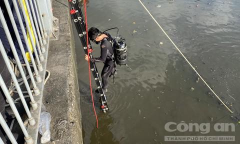 Cảnh sát lặn xuống dòng nước bẩn để tìm tang vật.