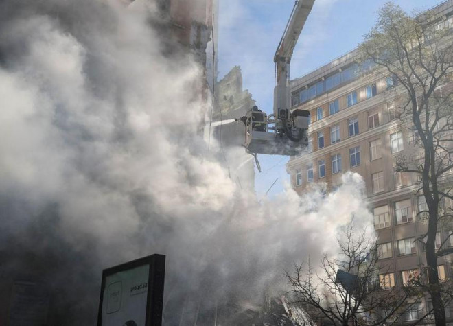 Lính cứu hỏa đang dập lửa tại khu chung cư bị UAV Nga tấn công ở thủ đô Kiev. Ảnh: REUTERS