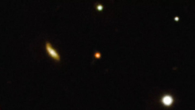 Chấm đỏ giữa màn hình chính là tín hiệu gamma "xuyên không" từ vũ trụ sơ khai - Ảnh: ESO