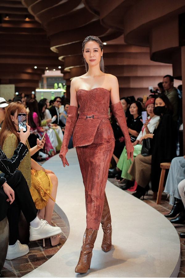 Đặc biệt ở bộ cánh vedette được Hoa hậu Dương Thuỳ Linh thể hiện, NTK Helene Hoài cùng ê kíp dành trọn tâm huyết khi sử dụng chất liệu đặc biệt - đất sét của Bát Tràng. Bộ váy 100% bằng đất sét được hoàn thiện trong hơn 100 giờ làm việc, thể hiện sự sáng tạo vượt qua khỏi khuôn khổ thời trang của NTK Helene Hoài để mang đến những giá trị nhân văn, tôn vinh làng gốm Bát Tràng. Bộ cánh với phần áo cúp ngực còn được Helene Hoài tỉ mỉ khắc hoạ bằng tay những đường vân nhằm tái hiện lại công đoạn các nghệ nhân Bát Tràng cũng miệt mài tạo hình cho đất sét trước khi đưa vào lò nung.&nbsp;