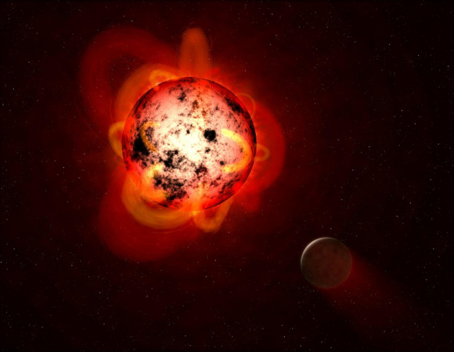 Ảnh đồ họa mô tả một sao lùn đỏ với bức xạ cuồng nộ dù nhiệt độ thấp hơn Mặt Trời, tắm hành tinh của nó trong ánh sáng đỏ dịu hơn nhưng bức xạ lại khủng khiếp hơn, đủ thổi bay bầu khí quyển - Ảnh: PHYS