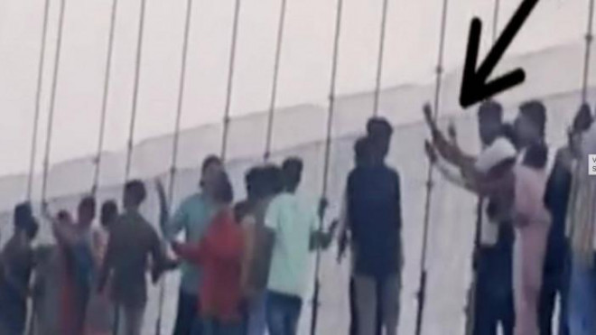 Nhóm thanh niên túm tụm nhảy và rung lắc cầu. Ảnh cắt từ video NDTV
