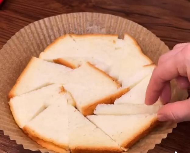 Đĩa giấy nến các bạn phết lót 1 lớp dầu ăn mỏng chống dính rồi cắt bánh mì gối và sắp xếp bánh mì vào đĩa giấy nến như hình hướng dẫn.