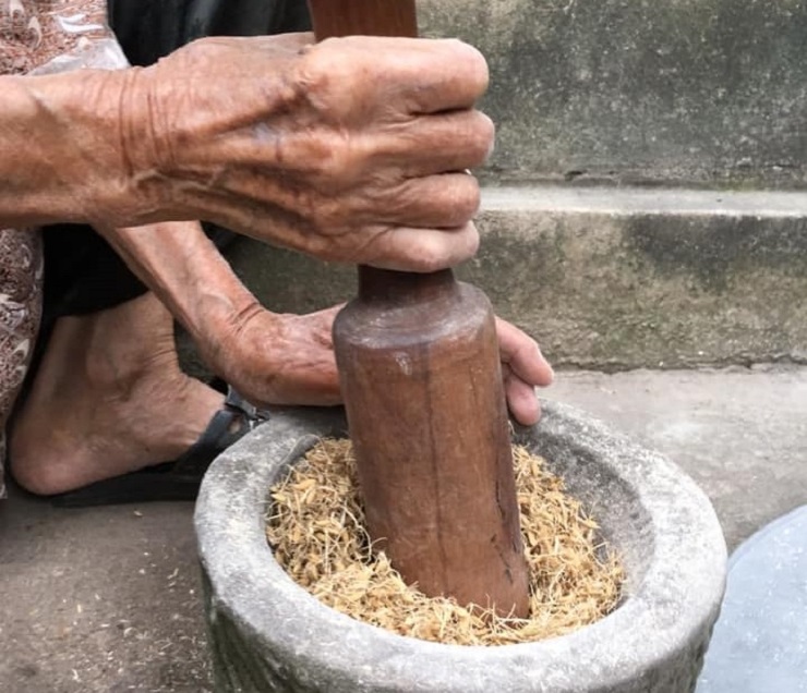 Tiếp đó mang mầm lúa đã phơi khô đi giã nhỏ, sàng bỏ đi những cánh trấu to rồi trộn với xôi nếp. (Ảnh: Từ Quang Đức).
