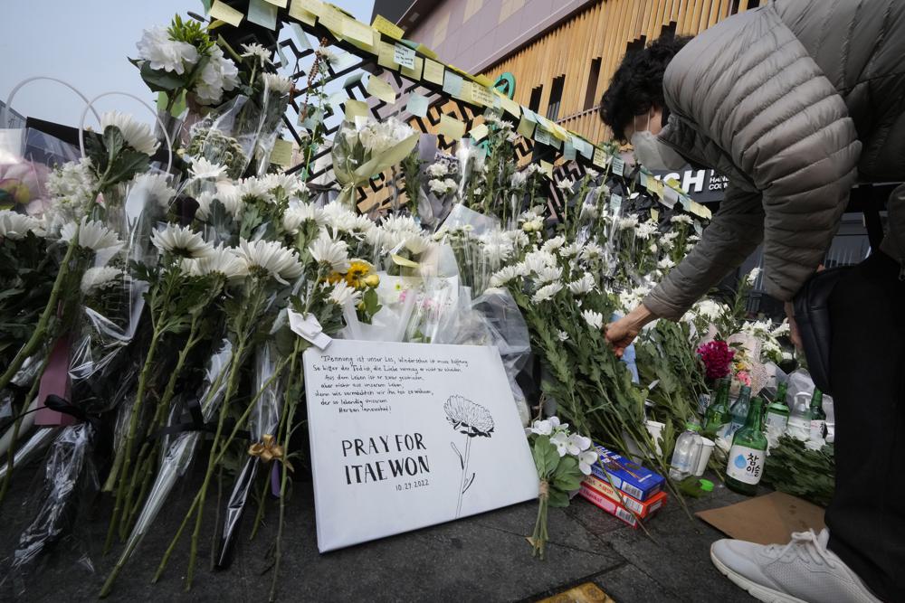 Một phụ nữ đặt hoa trắng tưởng niệm các nạn nhân tử vong trong thảm kịch ở lễ hội Halloween trên phố Itaewon, Seoul, Hàn Quốc.&nbsp; Ảnh: AP