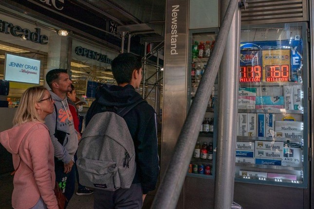 Người dân theo dõi bảng giải thưởng xổ số ở New York. Ảnh: Reuters