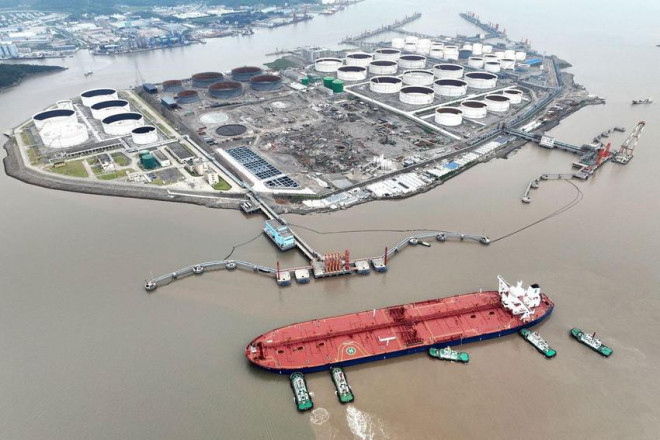 Ảnh chụp từ trên không cho thấy các tàu lai dắt giúp một tàu chở dầu thô cập bến, ngoài khơi TP Chu Sơn, tỉnh Chiết Giang (Trung Quốc) ngày 18-7. Ảnh: REUTERS