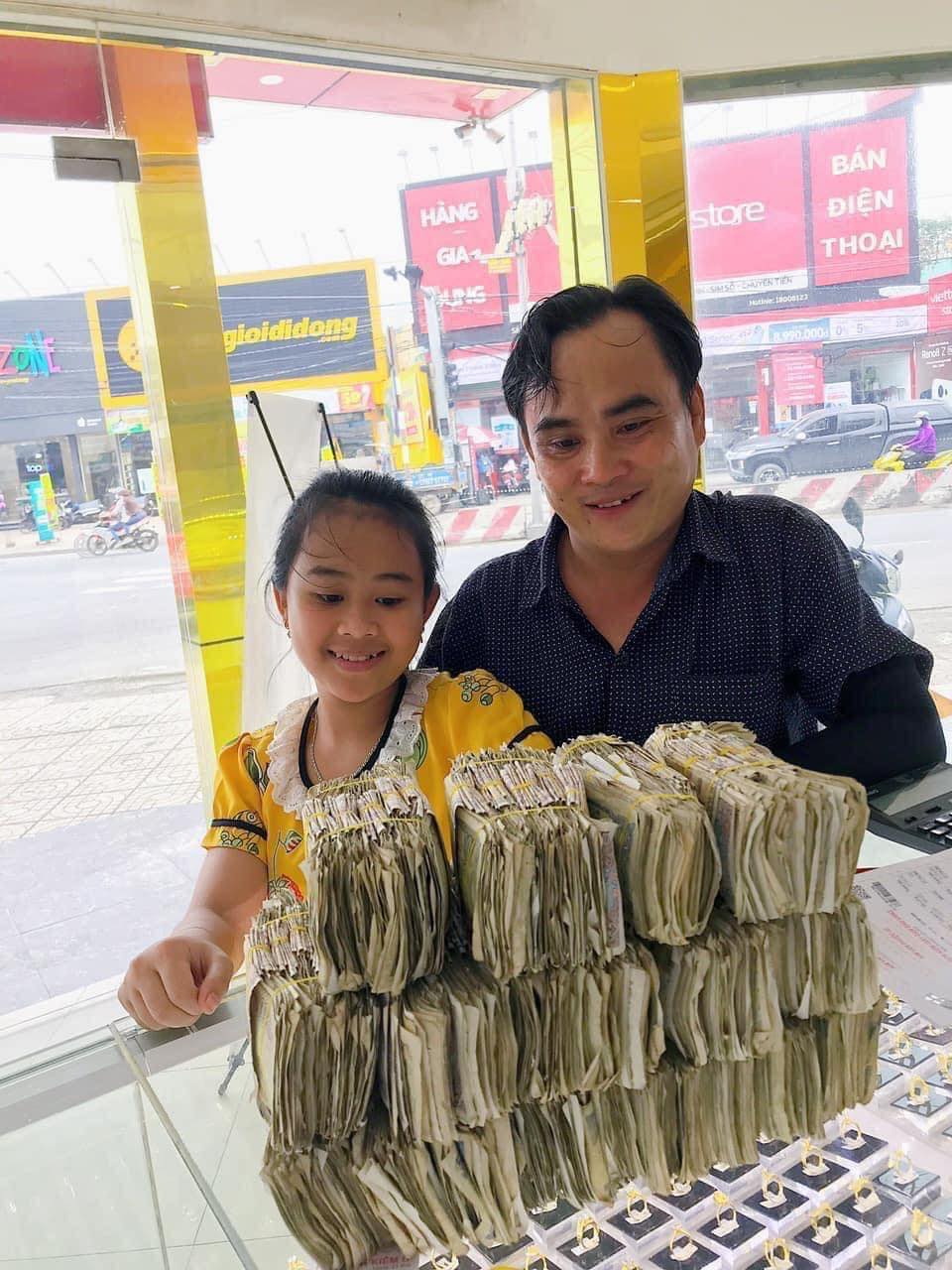 Hai bố con anh Tấn mang hơn 6kg tiền lẻ đi&nbsp;mua vàng.