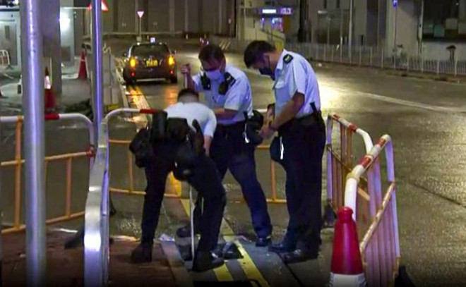 Cảnh sát kiểm tra hố ga nơi người đàn ông ngã xuống. Ảnh:&nbsp;Ảnh: NowTV News