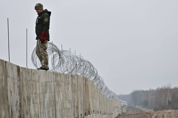 Lính Ukraine đứng trên tường biên giới với Belarus (ảnh: RT)