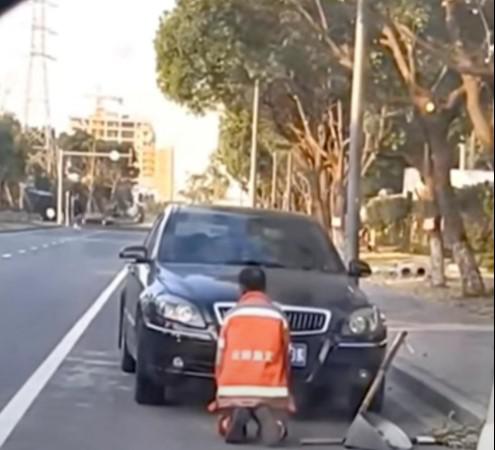 Hình ảnh công nhân vệ sinh lớn tuổi quỳ trước chiếc ô tô khiến nhiều cư dân mạng phẫn nộ. Ảnh: Weibo