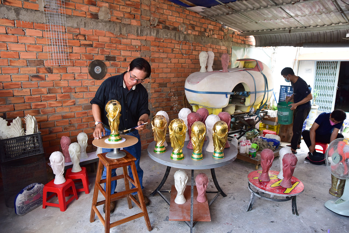 Mùa World Cup năm nay, xưởng làm đồ mỹ nghệ của Nguyễn Văn Tám (55 tuổi), xã Tân Thông Hội, huyện Củ Chi, TP.HCM làm hàng trăm chiếc cup vàng World Cup phục vụ những người yêu lễ hội bóng đá lớn nhất hành tinh.