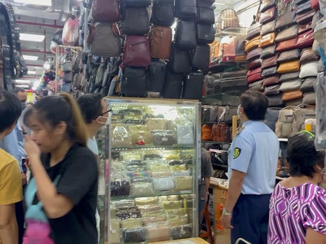 Tại TTTM An Đông (quận 5), lực lượng chức năng kiểm tra các sản phẩm túi xách, giày dép...