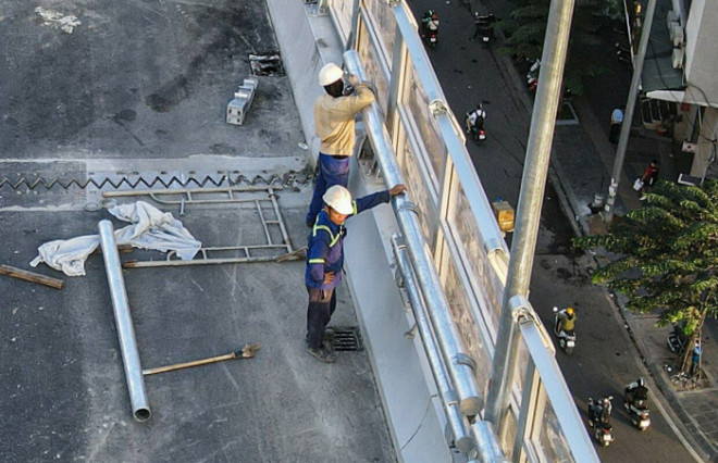 Trong ảnh, công nhân đang hoàn thiện lắp tấm chống ồn trên lan can dọc hai bên đường với chiều dài 5km.