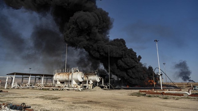 Khói bốc lên từ một kho chứa dầu bị không quân Thổ Nhĩ Kỳ tấn công gần thị trấn Qamishli, Syria hôm 23/11. Ảnh: AP