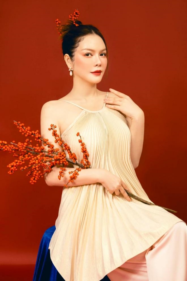 Lý Nhã Kỳ khoe nét gợi cảm, sang trọng khi diện áo có thiết kế cổ yếm, búi tóc cao trong bộ ảnh chào xuân.
