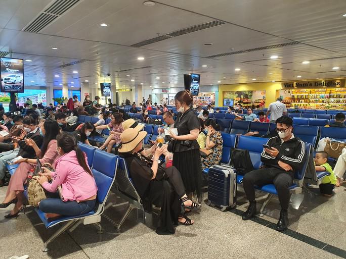 Mưa lớn ảnh hưởng nhiều chuyến bay tại sân bay Tân Sơn Nhất chiều 3-12. Trong ảnh: Hành khách chờ ra cửa khởi hành ở sân bay