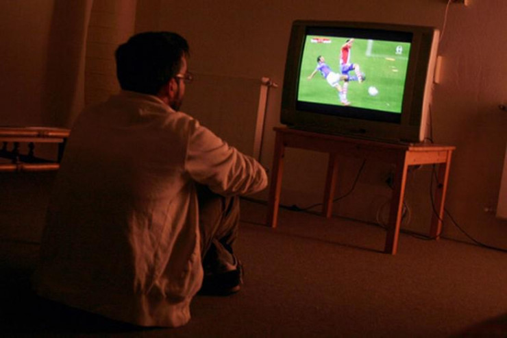 Người đàn ông thức suốt đêm để xem bóng đá. Ảnh minh họa