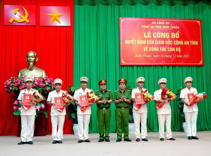 Đại tá Đinh Kim Lập và Thượng tá Huỳnh Ngọc Liêm trao quyết định, tặng hoa cho sáu sĩ quan vừa được điều động, bổ nhiệm. Ảnh: NHƯ Ý
