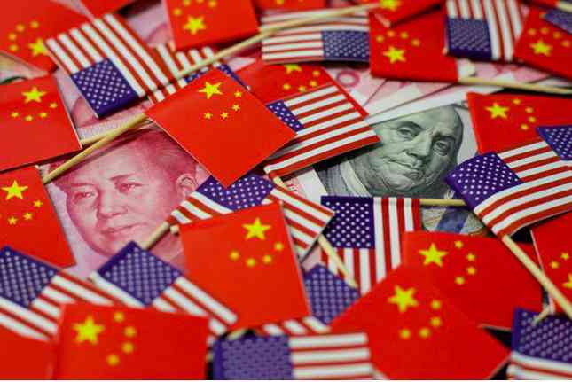 Hình ảnh đồng nhân dân tệ và đô la Mỹ cùng quốc kỳ của hai siêu cường. (Ảnh: Reuters)