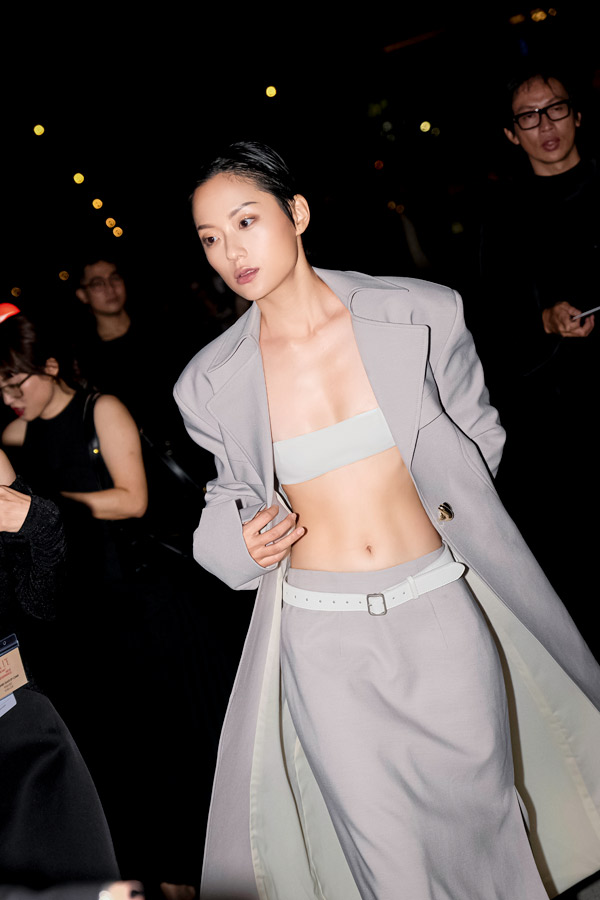 Hồ Thu Anh trong thiết kế áo trench coat đứng form phối cùng bralette tạo những khoảng kín hở có tính toán. 
